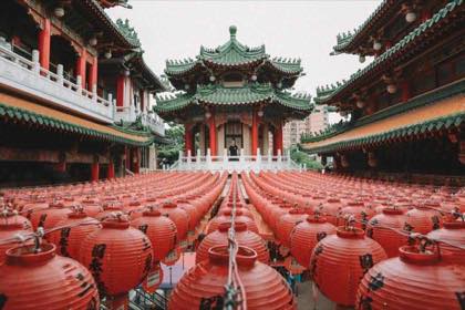 台灣廟宇前庭懸掛成排紅色燈籠，後方為綠瓦飛簷的傳統建築