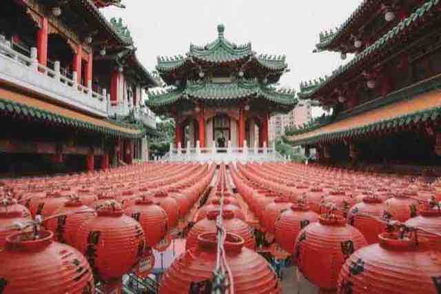 台灣廟宇前庭懸掛成排紅色燈籠,後方為綠瓦飛簷的傳統建築